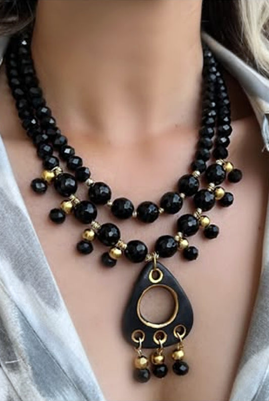 Two-strand faceted black bead necklace set with a gold-ringed black teardrop pendant
