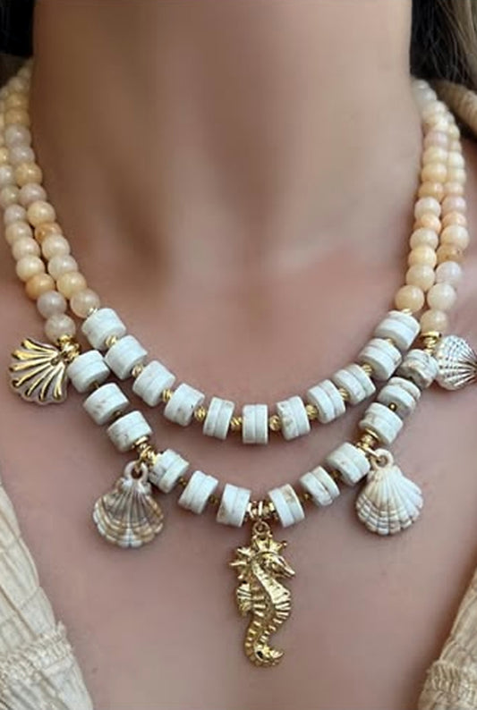 Two-strand cream and peach beaded necklace set with gold shell and seahorse charms