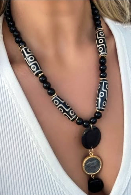 Single strand black agate necklace with patterned Tibetan dzi beads and a gold-rimmed disc